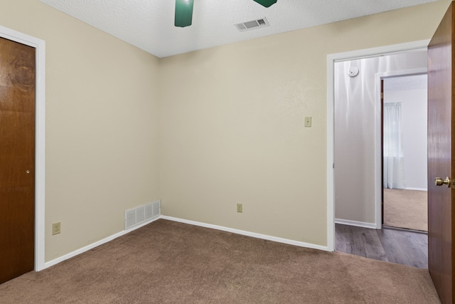 unfurnished bedroom with carpet flooring, ceiling fan, and a textured ceiling