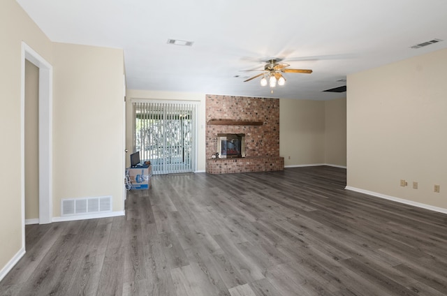 unfurnished living room with dark hardwood / wood-style floors, a brick fireplace, and ceiling fan