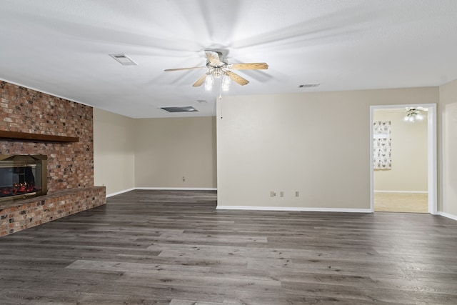 unfurnished living room featuring a fireplace, ceiling fan, and dark wood-type flooring