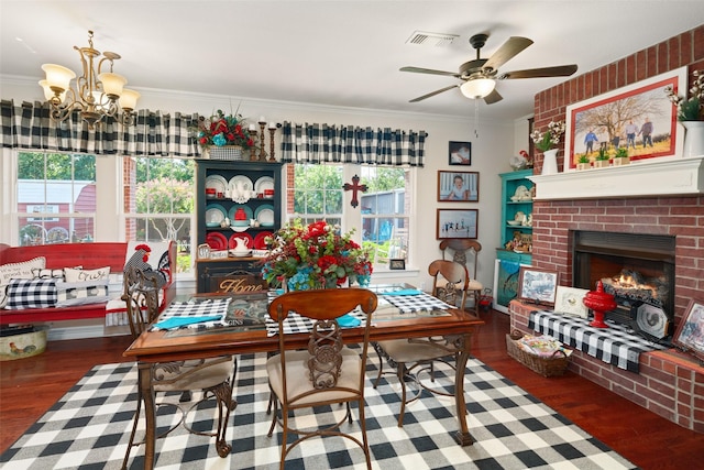 dining room featuring a fireplace, ceiling fan with notable chandelier, dark hardwood / wood-style floors, and ornamental molding