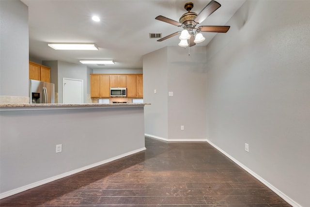 kitchen featuring ceiling fan, light brown cabinetry, dark hardwood / wood-style floors, and appliances with stainless steel finishes