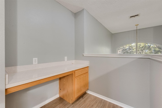 unfurnished office with a textured ceiling and light hardwood / wood-style floors