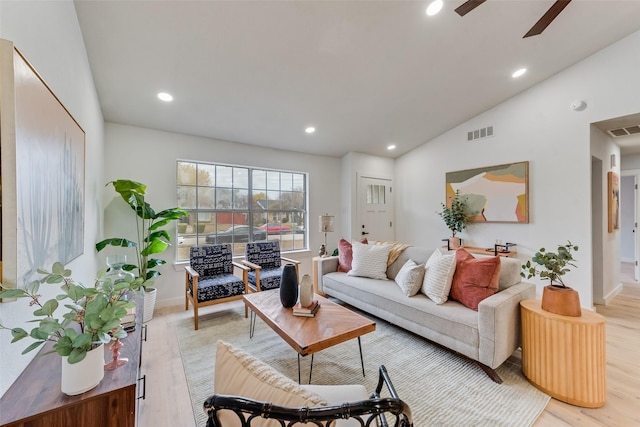 living room with ceiling fan, light hardwood / wood-style floors, and lofted ceiling