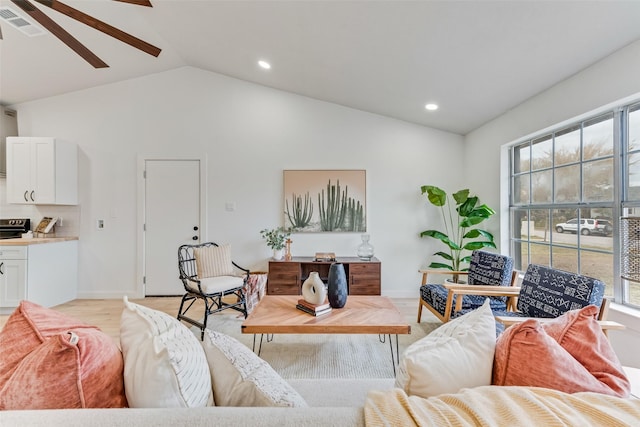 living room featuring ceiling fan, light hardwood / wood-style floors, and vaulted ceiling