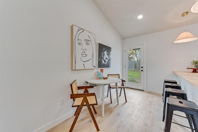 dining area featuring light hardwood / wood-style flooring and lofted ceiling