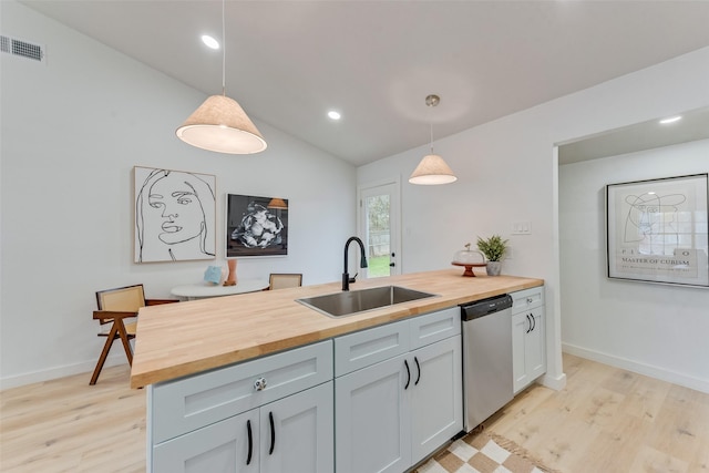 kitchen featuring hanging light fixtures, wooden counters, and stainless steel dishwasher