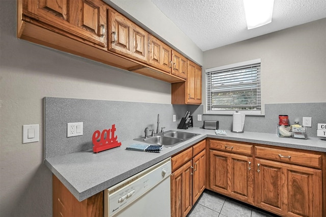 kitchen with sink, a textured ceiling, light tile patterned floors, and dishwasher