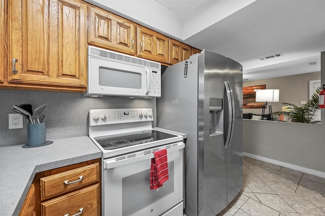 kitchen with white appliances and light tile patterned flooring