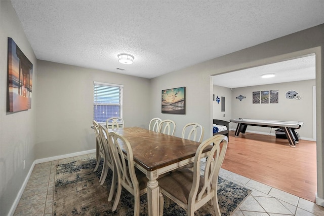 tiled dining room with a textured ceiling