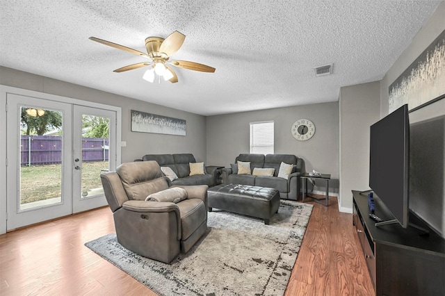 living room with wood-type flooring, ceiling fan, a healthy amount of sunlight, and french doors