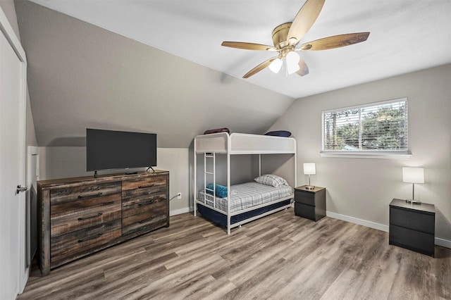 bedroom featuring ceiling fan, wood-type flooring, and lofted ceiling