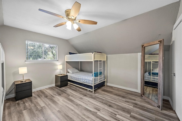 bedroom featuring ceiling fan, vaulted ceiling, and hardwood / wood-style floors