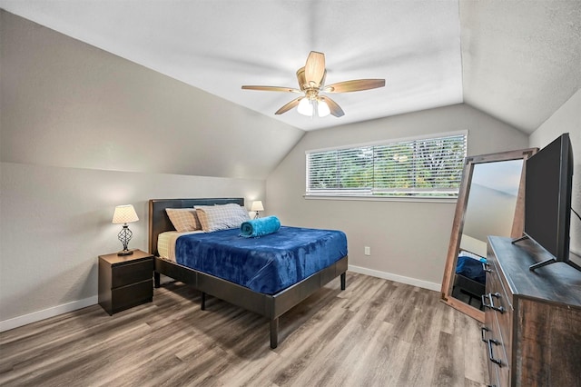 bedroom with vaulted ceiling, ceiling fan, and light hardwood / wood-style flooring