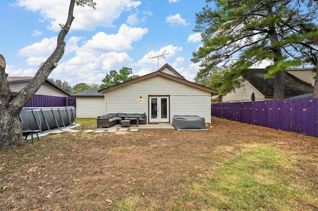 back of property featuring a fenced in pool, an outdoor hangout area, french doors, and a lawn