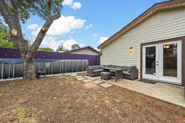 view of yard featuring an outdoor hangout area, french doors, a patio area, and a covered pool