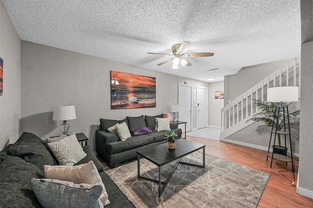 living room featuring ceiling fan, a textured ceiling, and hardwood / wood-style floors