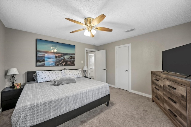 bedroom featuring ceiling fan, a textured ceiling, and light carpet