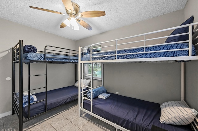 tiled bedroom with ceiling fan and a textured ceiling