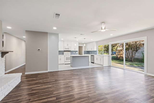 unfurnished living room featuring hardwood / wood-style flooring, ceiling fan, and a brick fireplace