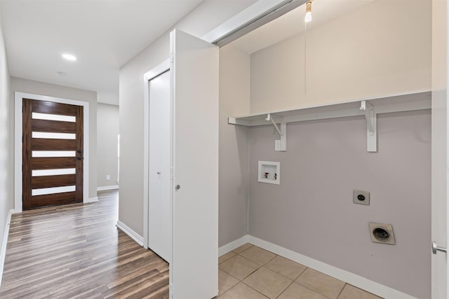 laundry area with hookup for an electric dryer, hookup for a washing machine, and light wood-type flooring