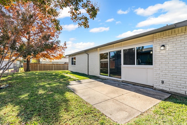 rear view of house with a lawn and a patio area