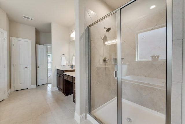 bathroom featuring tile patterned flooring, vanity, and a shower with door