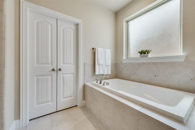 bathroom featuring tiled tub and tile patterned flooring