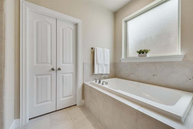 bathroom with tile patterned flooring and tiled tub