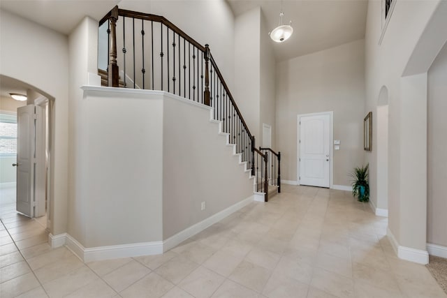 foyer featuring a towering ceiling and light tile patterned floors