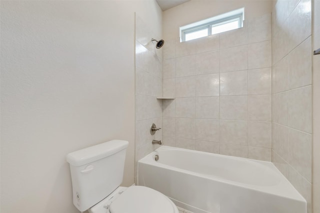 bathroom featuring toilet and tiled shower / bath