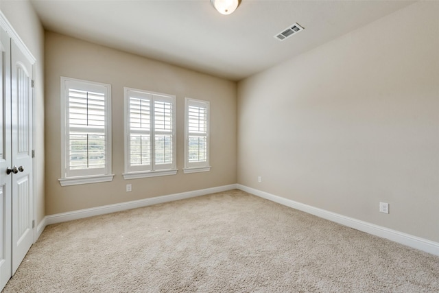 unfurnished room featuring light colored carpet