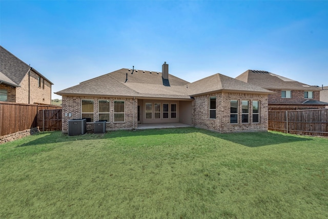 rear view of house with central air condition unit, a patio area, and a lawn