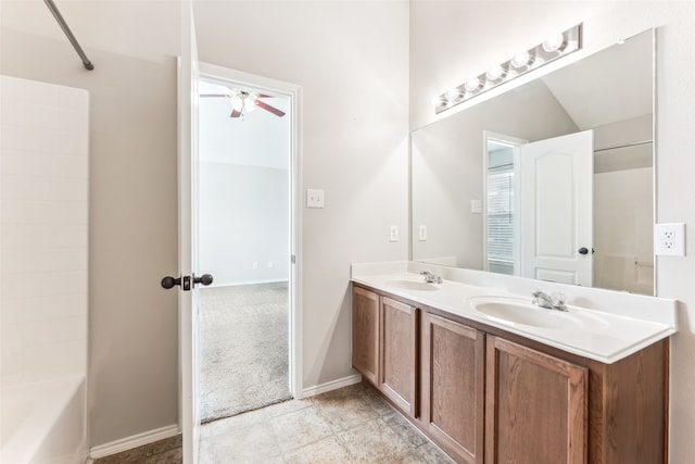 bathroom featuring ceiling fan, washtub / shower combination, vanity, and vaulted ceiling