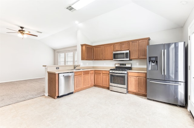 kitchen with ceiling fan, sink, light colored carpet, vaulted ceiling, and appliances with stainless steel finishes