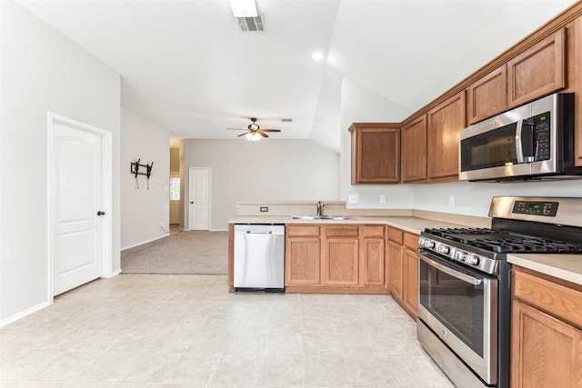 kitchen with lofted ceiling, sink, ceiling fan, appliances with stainless steel finishes, and light tile patterned flooring