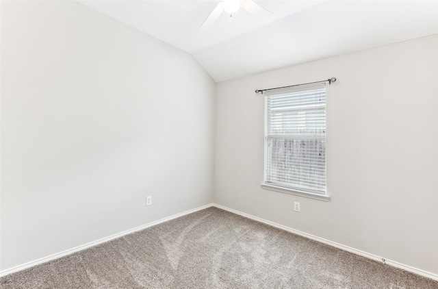 carpeted spare room featuring ceiling fan and vaulted ceiling