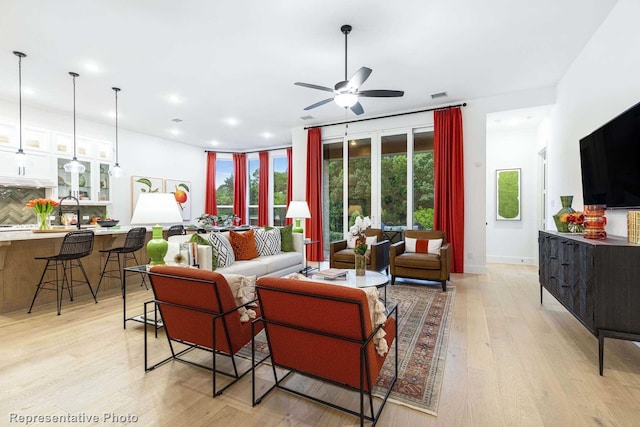 living room with ceiling fan and light wood-type flooring