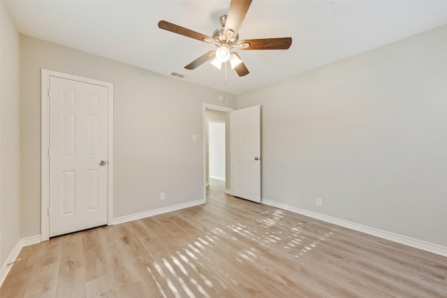 empty room with ceiling fan and light hardwood / wood-style flooring