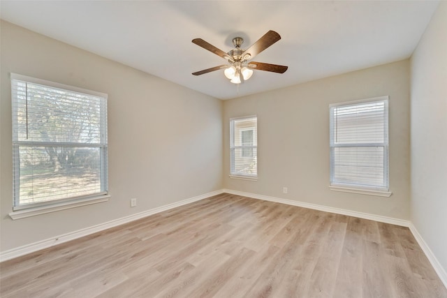 spare room featuring ceiling fan, light hardwood / wood-style flooring, and a healthy amount of sunlight