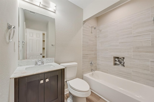 full bathroom featuring toilet, vanity, hardwood / wood-style floors, and tiled shower / bath