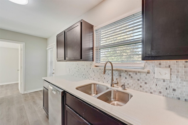 kitchen featuring backsplash, stainless steel dishwasher, dark brown cabinets, sink, and light hardwood / wood-style floors