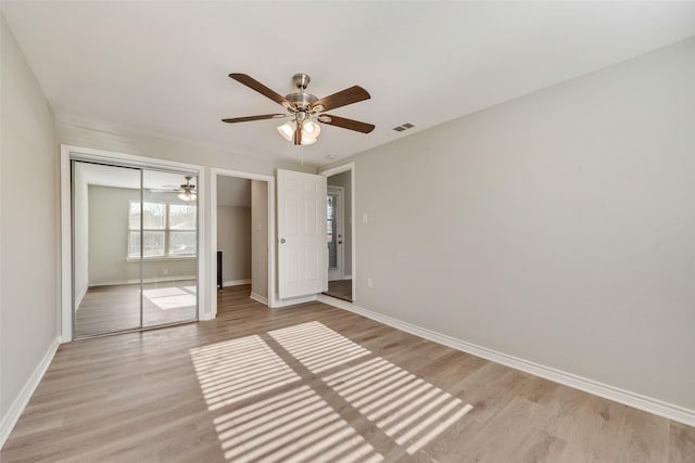 unfurnished bedroom featuring ceiling fan, light hardwood / wood-style flooring, and a closet