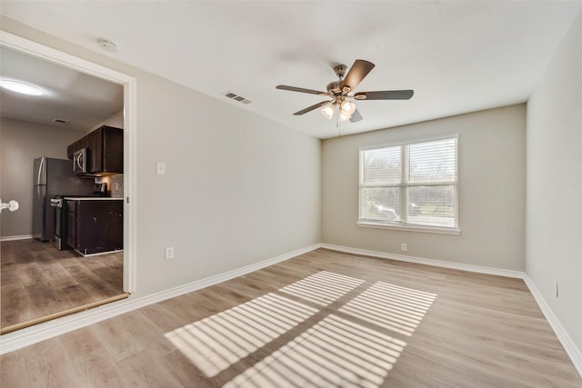 spare room with ceiling fan and light hardwood / wood-style flooring