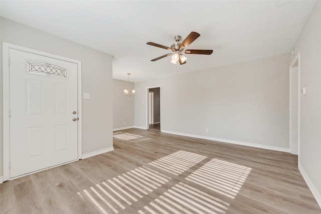 interior space featuring ceiling fan with notable chandelier and light wood-type flooring