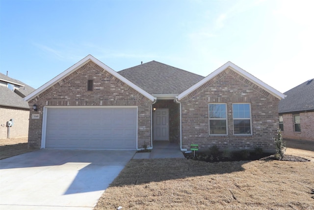 ranch-style home featuring brick siding, driveway, an attached garage, and roof with shingles