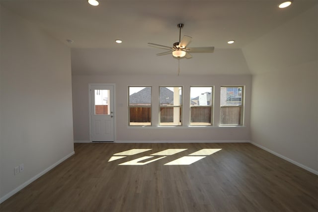 unfurnished living room with ceiling fan, recessed lighting, dark wood-type flooring, baseboards, and vaulted ceiling