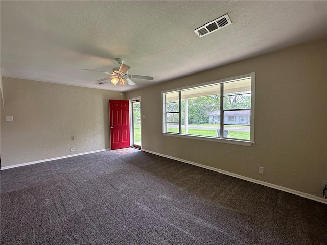 empty room with carpet flooring, ceiling fan, and a textured ceiling