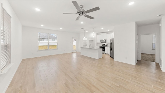 unfurnished living room featuring ceiling fan and light hardwood / wood-style flooring