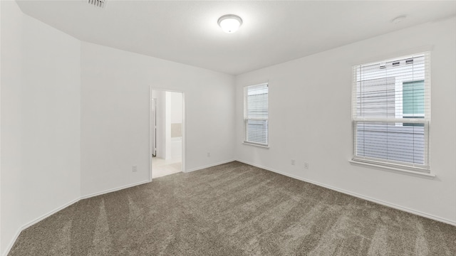 spare room with carpet and baseboards