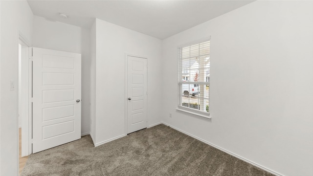 unfurnished bedroom featuring carpet flooring and baseboards